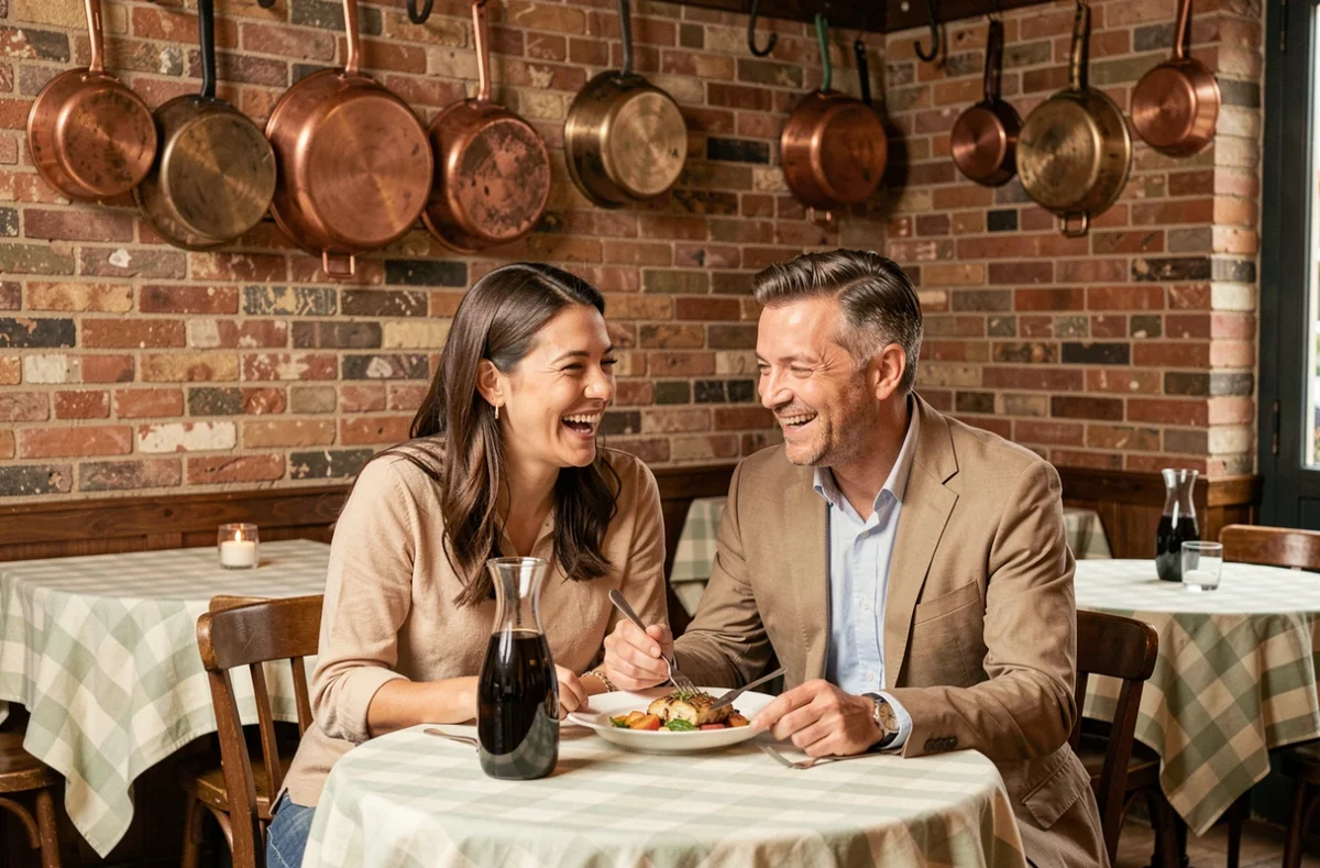 Intérieur convivial du bistrot Beurre Noisette à Lyon, couple riant autour d'un plat français classique et d'un carafe de Beaujolais sous des casseroles en cuivre